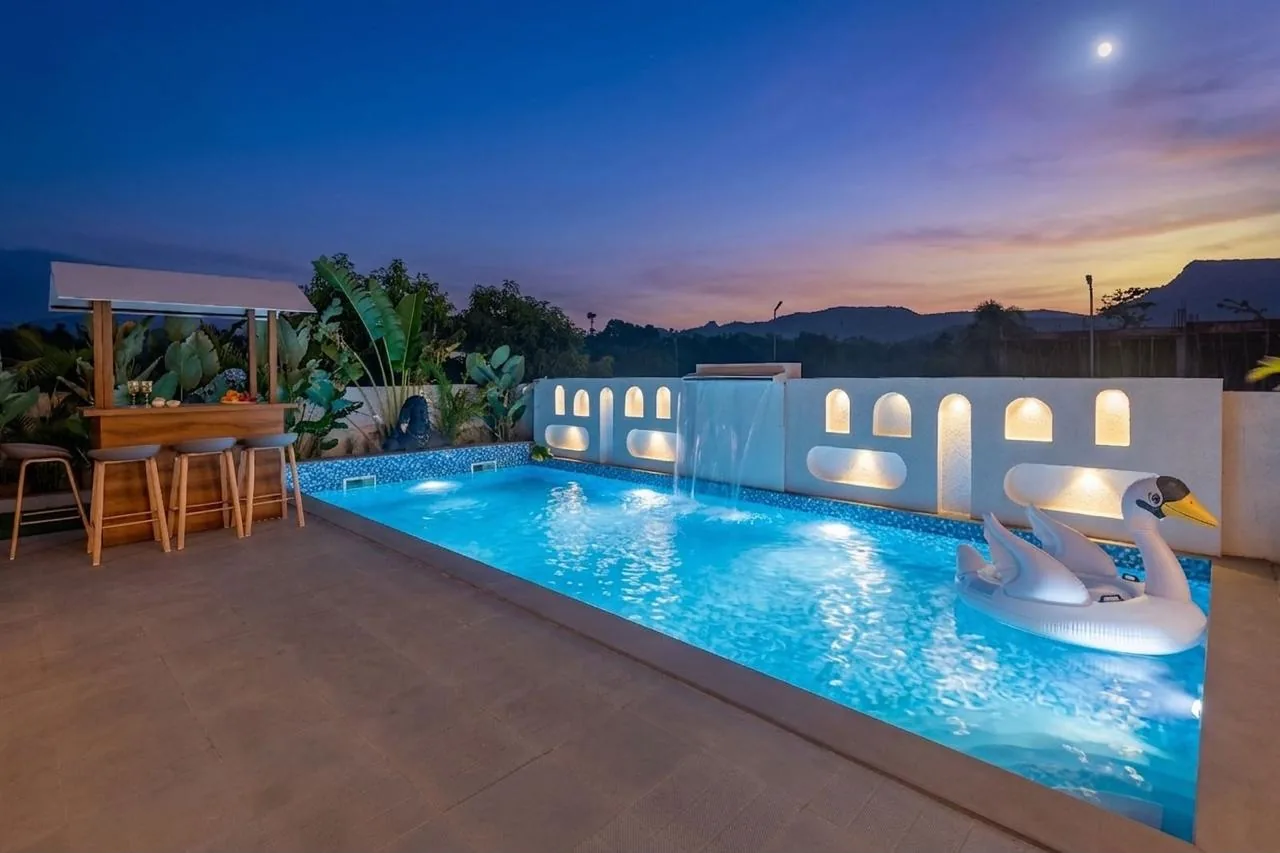 The private pool at dusk, the lit niches behind it